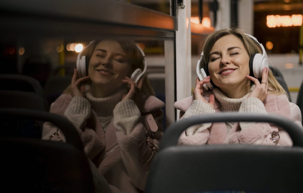 Girl on bus with headphones sitting on a bus, staying connected when abroad
