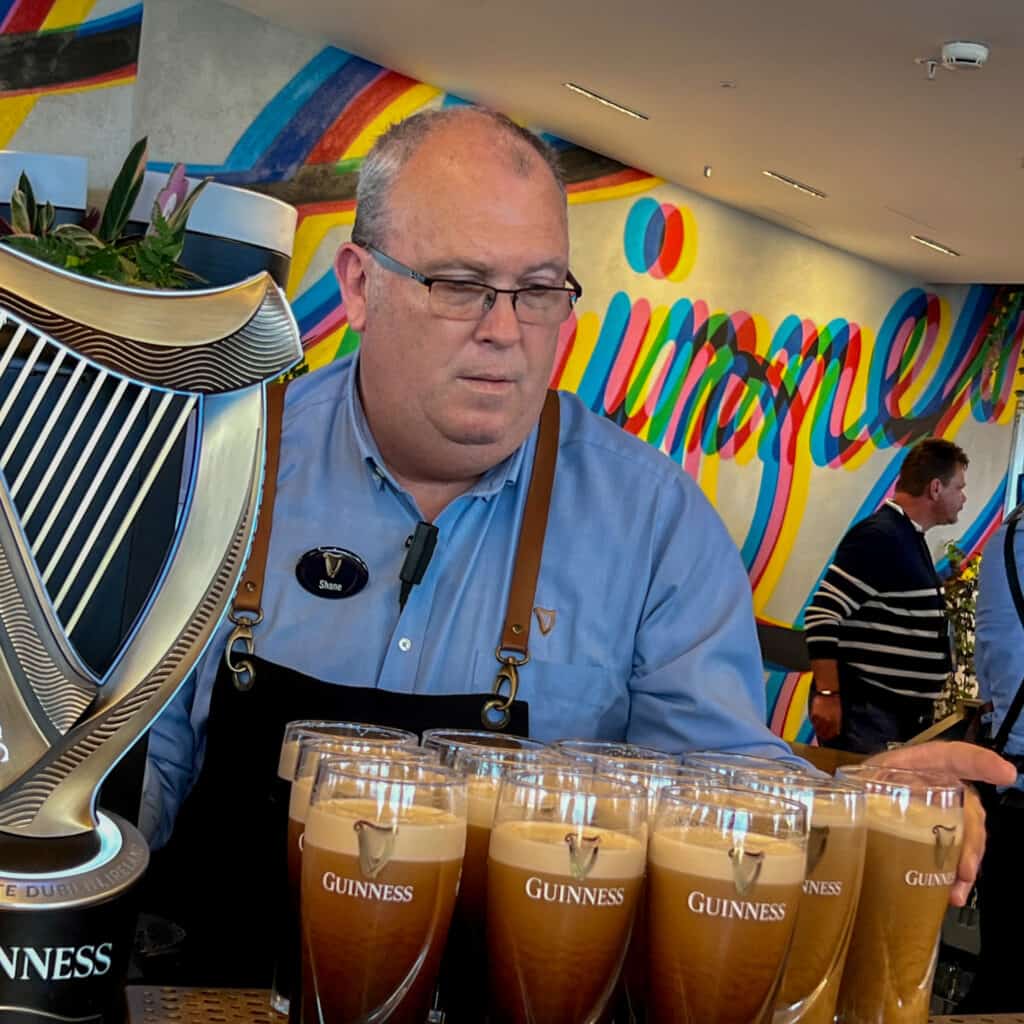 Barman pouring beer at Guinness roof top bar in Dublin