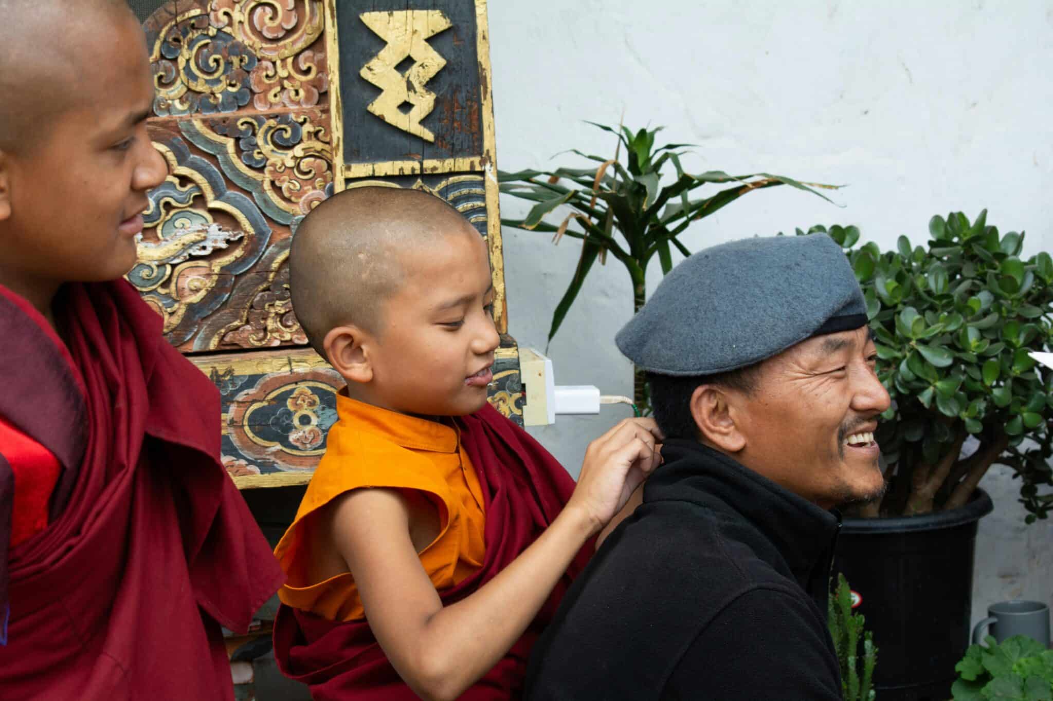 Young Buddhist monks laughing together in traditional attire, capturing the essence of Bhutanese culture.