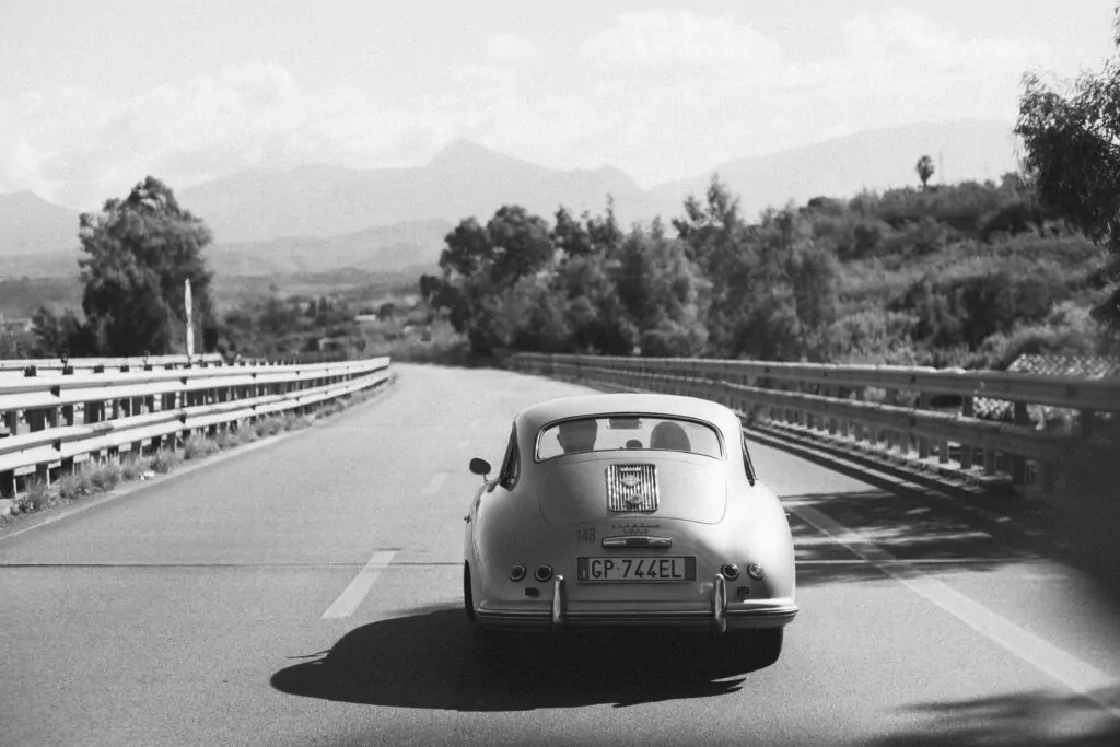 A classic Porsche travels through the picturesque roads of Sicilia, Italy.
