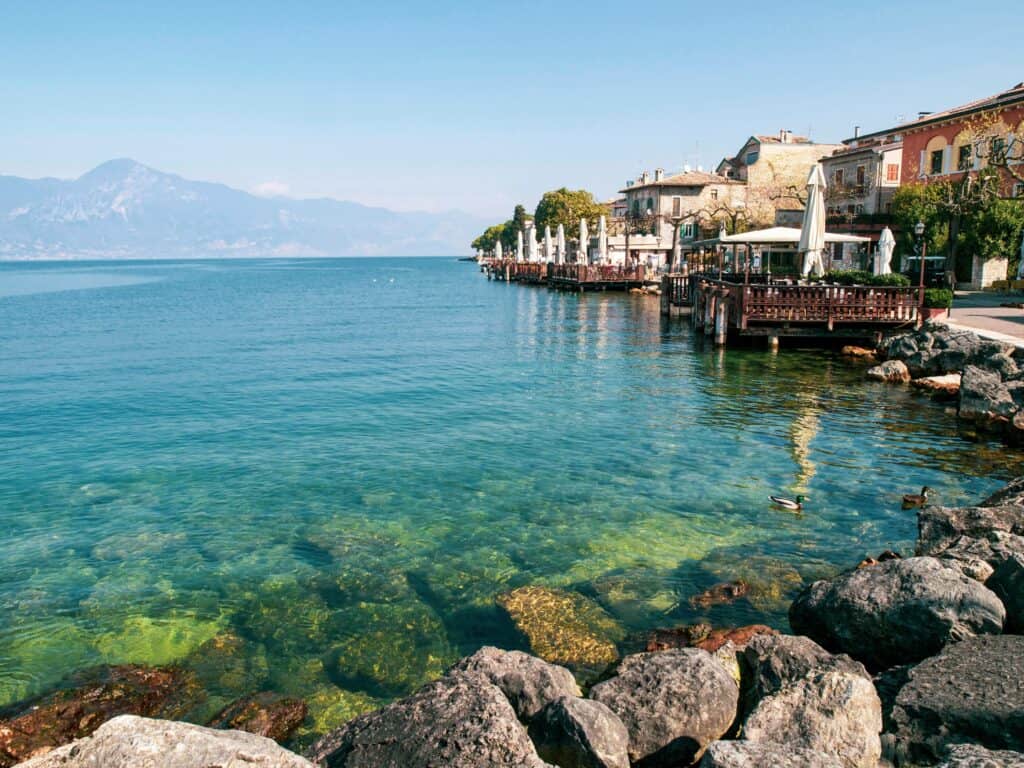 Idyllic view of Gardone Riviera with clear turquoise water and charming architecture. Perfect for travel inspiration.