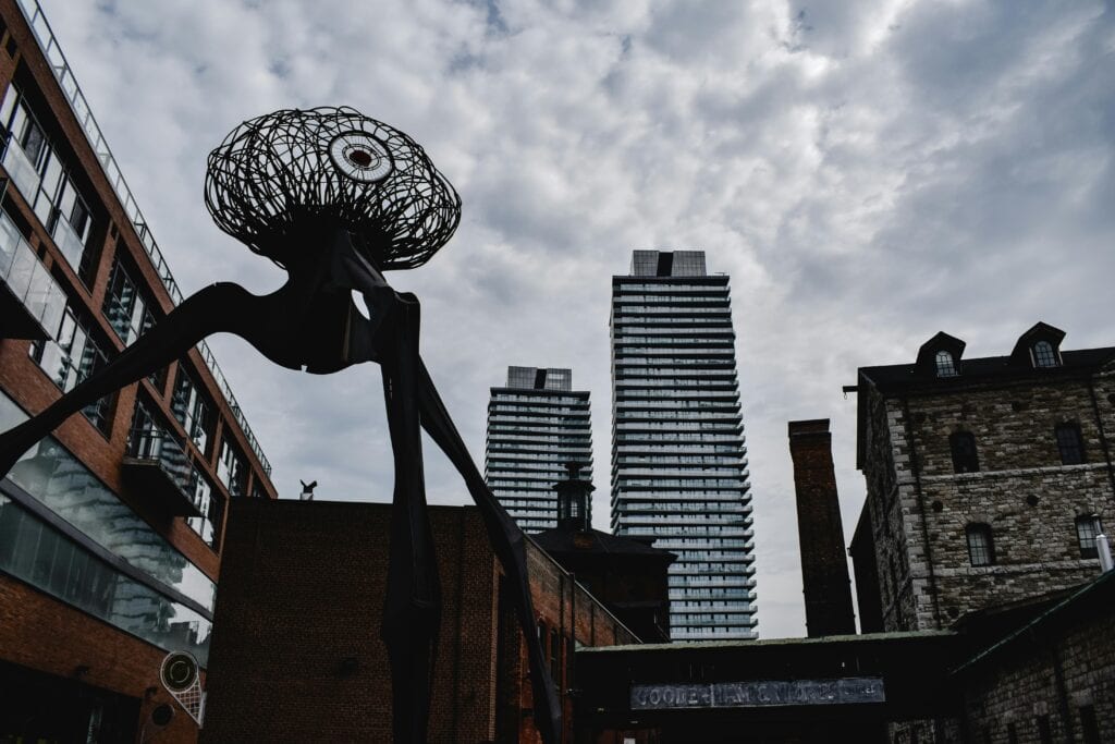 Dramatic sculpture set against the urban skyline of Toronto's Distillery District.