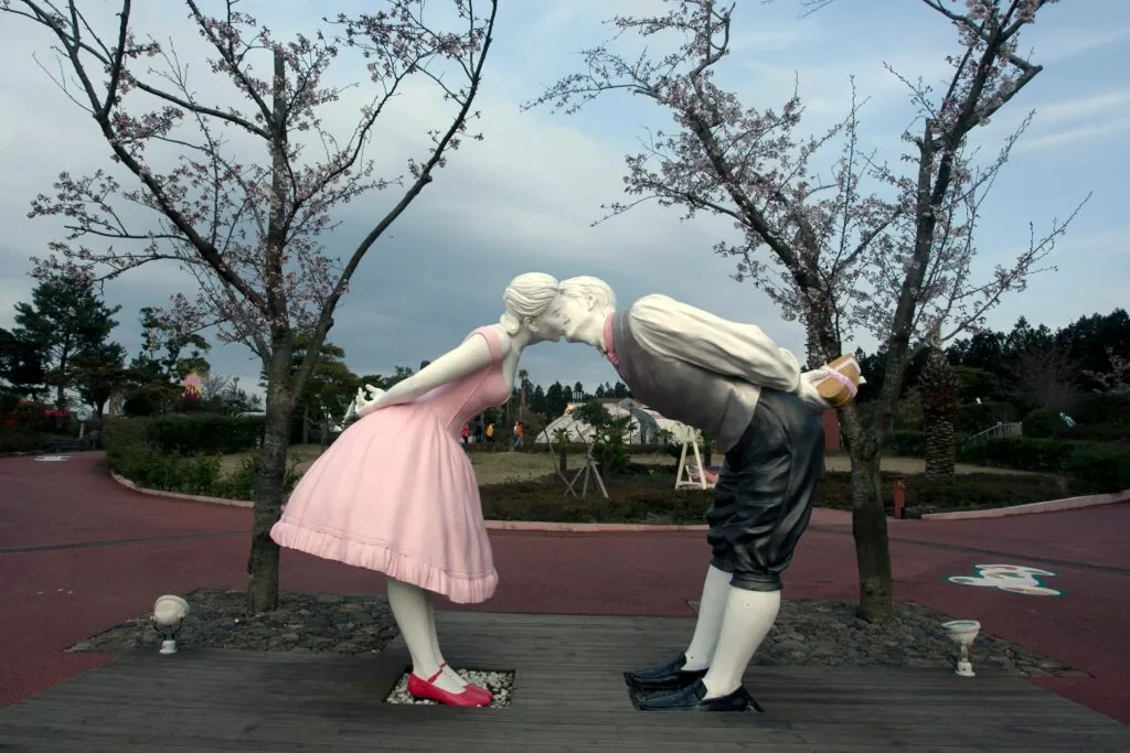 A sculpture of a couple kissing surrounded by cherry blossom trees in Love Land Park, South Korea.