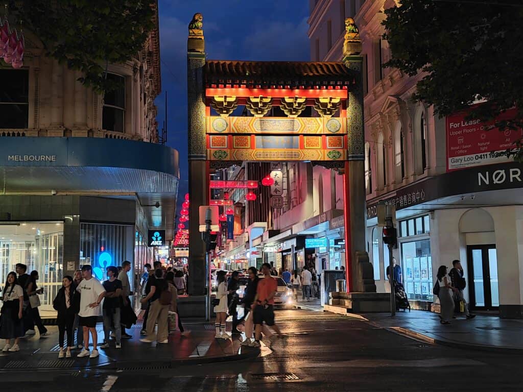 Vibrant street scene in Melbourne's Chinatown at night with colorful lights.