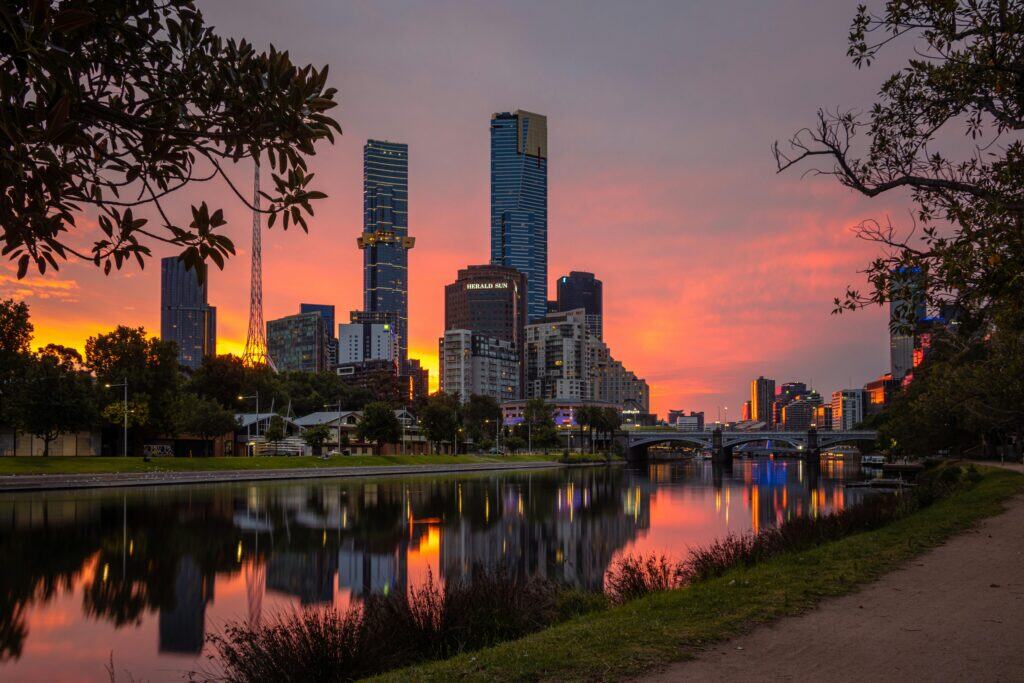 Captivating view of Melbourne's skyline and Yarra River at sunset showcasing vibrant colors and urban reflections.
