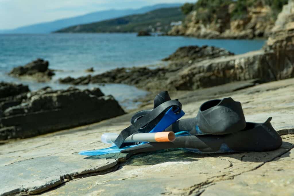 Snorkelling gear on a rocky seaside, perfect for adventures and exploring nature.Helping the environment while travelling 