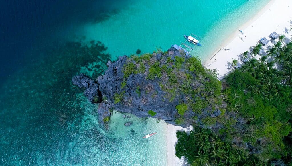 Stunning aerial shot of a tropical island in El Nido, showcasing pristine beaches and turquoise waters.