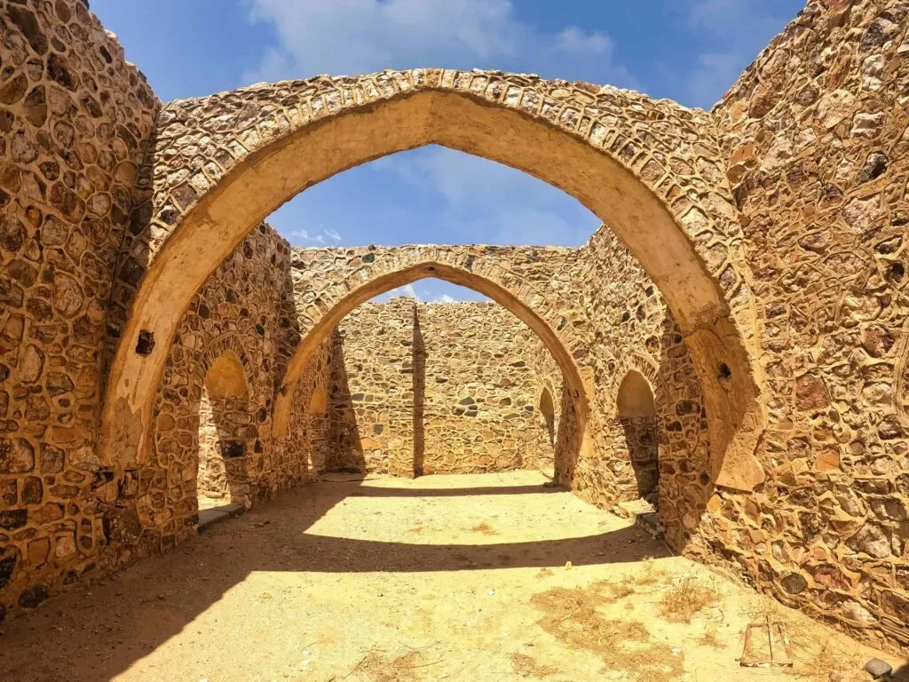 Historic stone arches and walls in sunny Taif, capturing ancient architectural beauty.