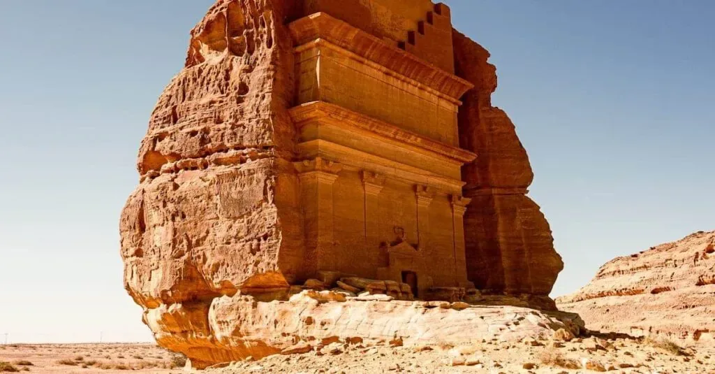 Sunlit rock-cut tomb in AlUla's desert landscape, Saudi Arabia.