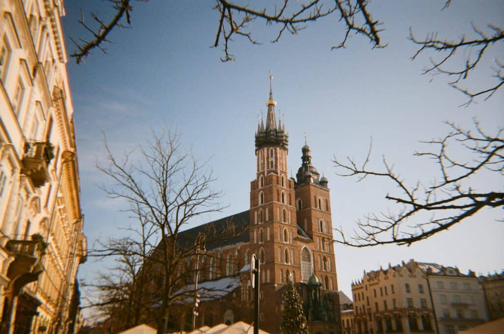 St. Mary’s Basilica in Krakow, Poland captured with an analog feel, framed by bare branches.