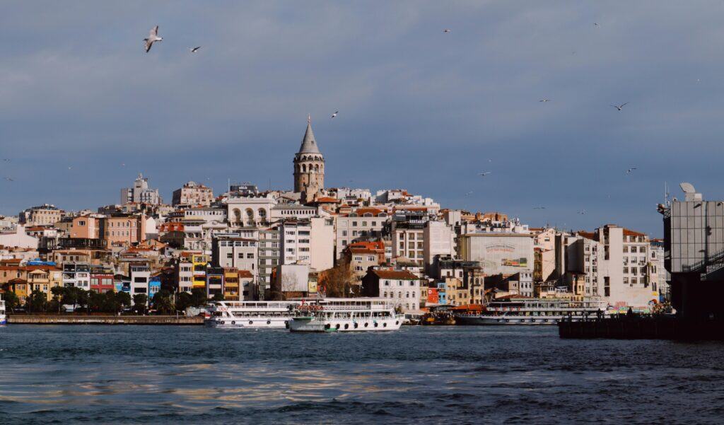 Galata Tower and boats under a clear sky in Istanbul, Turkey.