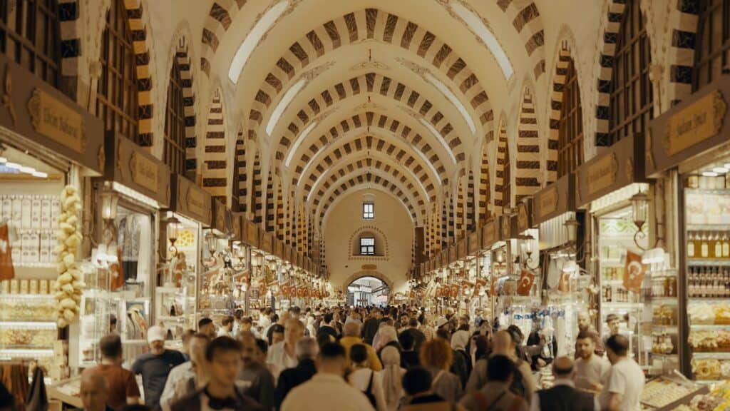 Crowds exploring the vibrant Grand Bazaar in Istanbul, showcasing traditional architecture and bustling market life.