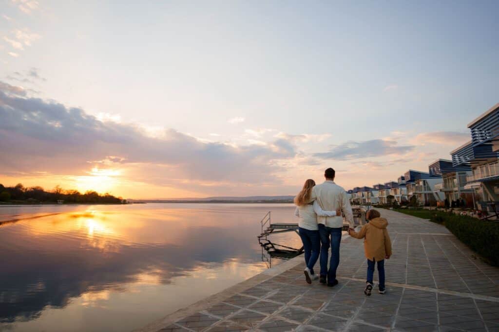 slower travel, couple and child walk along the waters edge