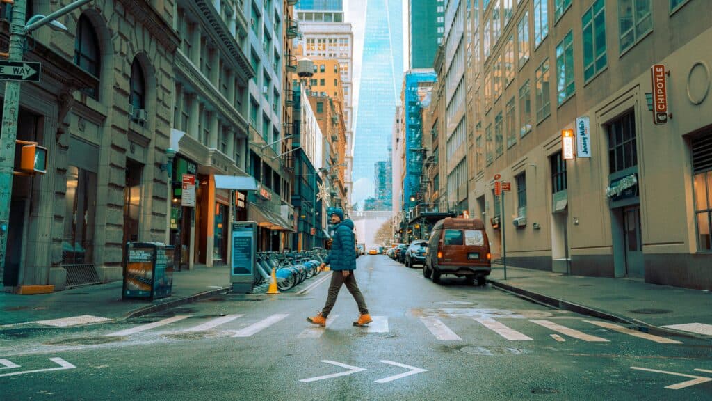 A person crosses a street in downtown Manhattan, New York during winter.