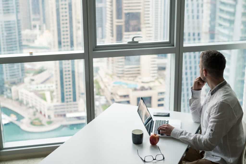 Businessman in a modern office looking through the window.