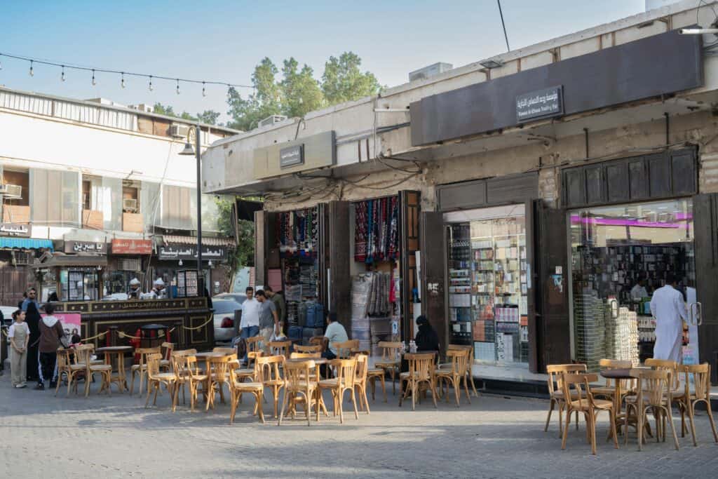 Lively Middle Eastern market scene with outdoor seating and local shops, capturing vibrant local culture.
