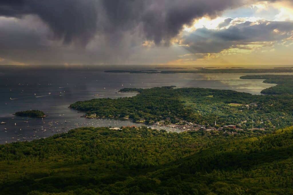 A stunning aerial view of a lush coastal landscape with a dramatic sky at dusk.