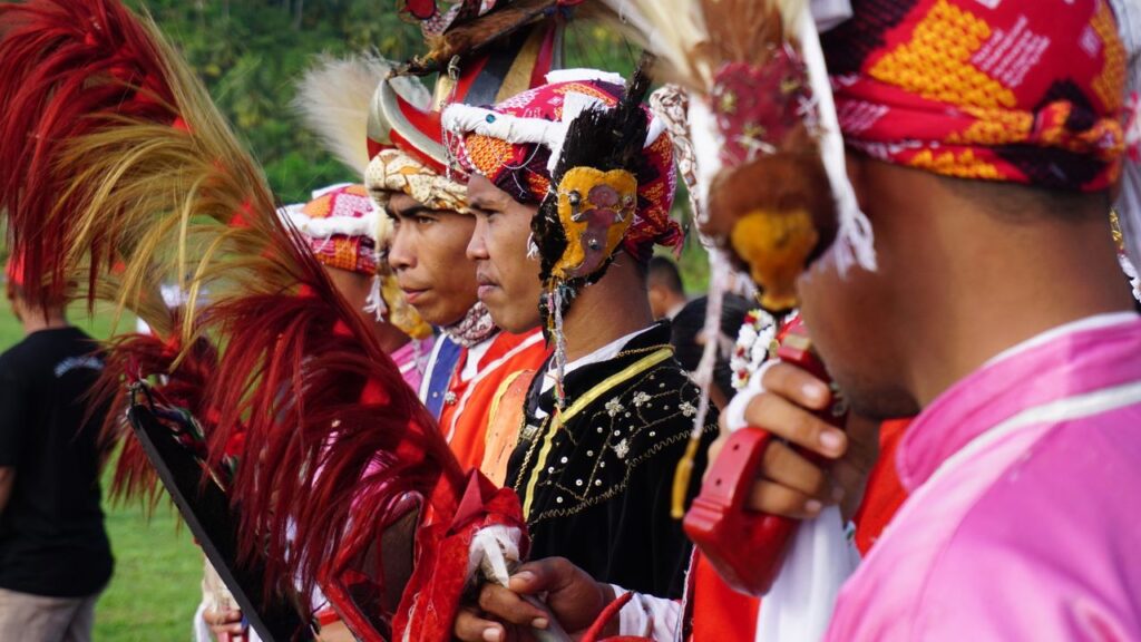 Men in traditional costumes perform a ceremonial warrior dance in Banda Neira, Indonesia.