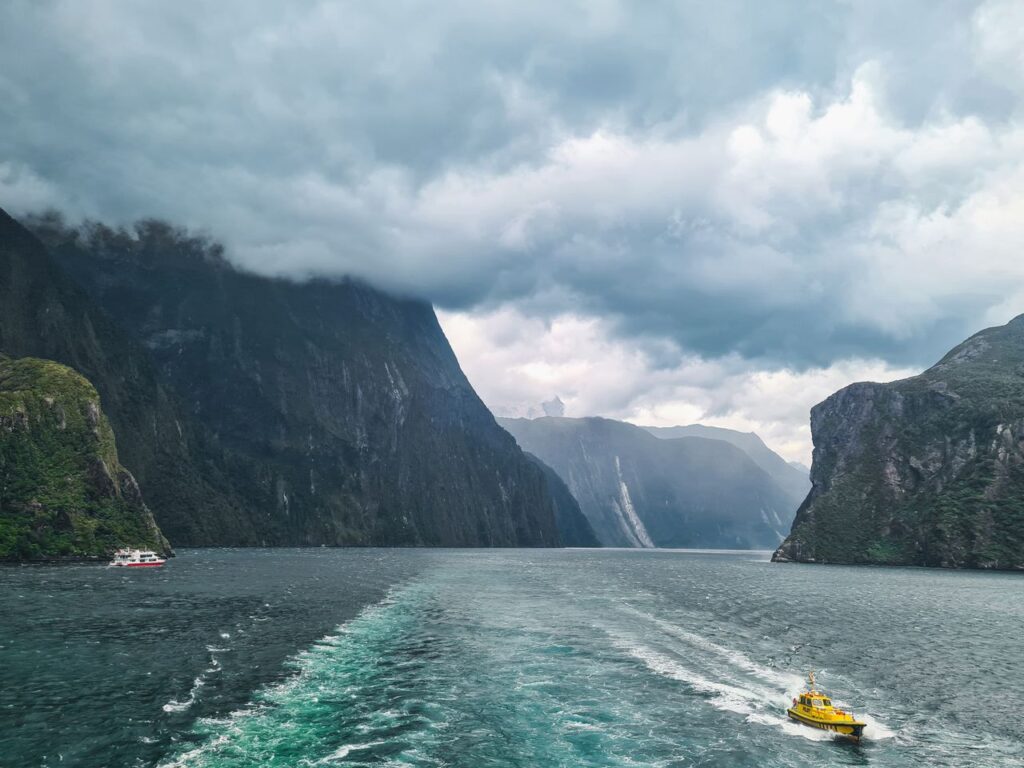 Picturesque view of Milford Sound with boats navigating through stunning fjord landscape in New Zealand.