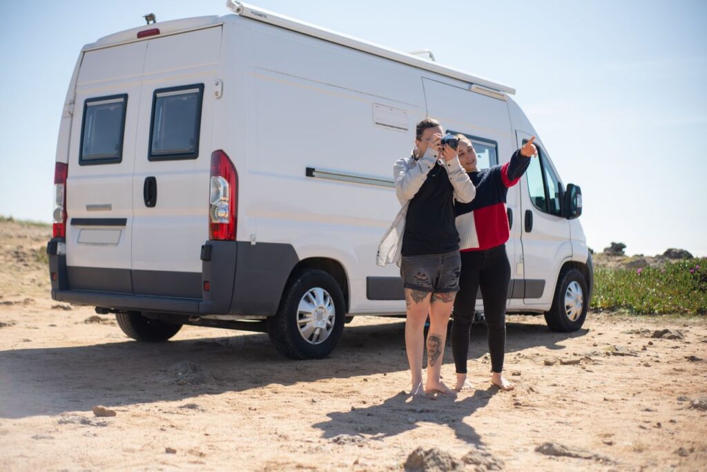 A couple enjoys a summer road trip in a campervan on the scenic Portuguese coastline.